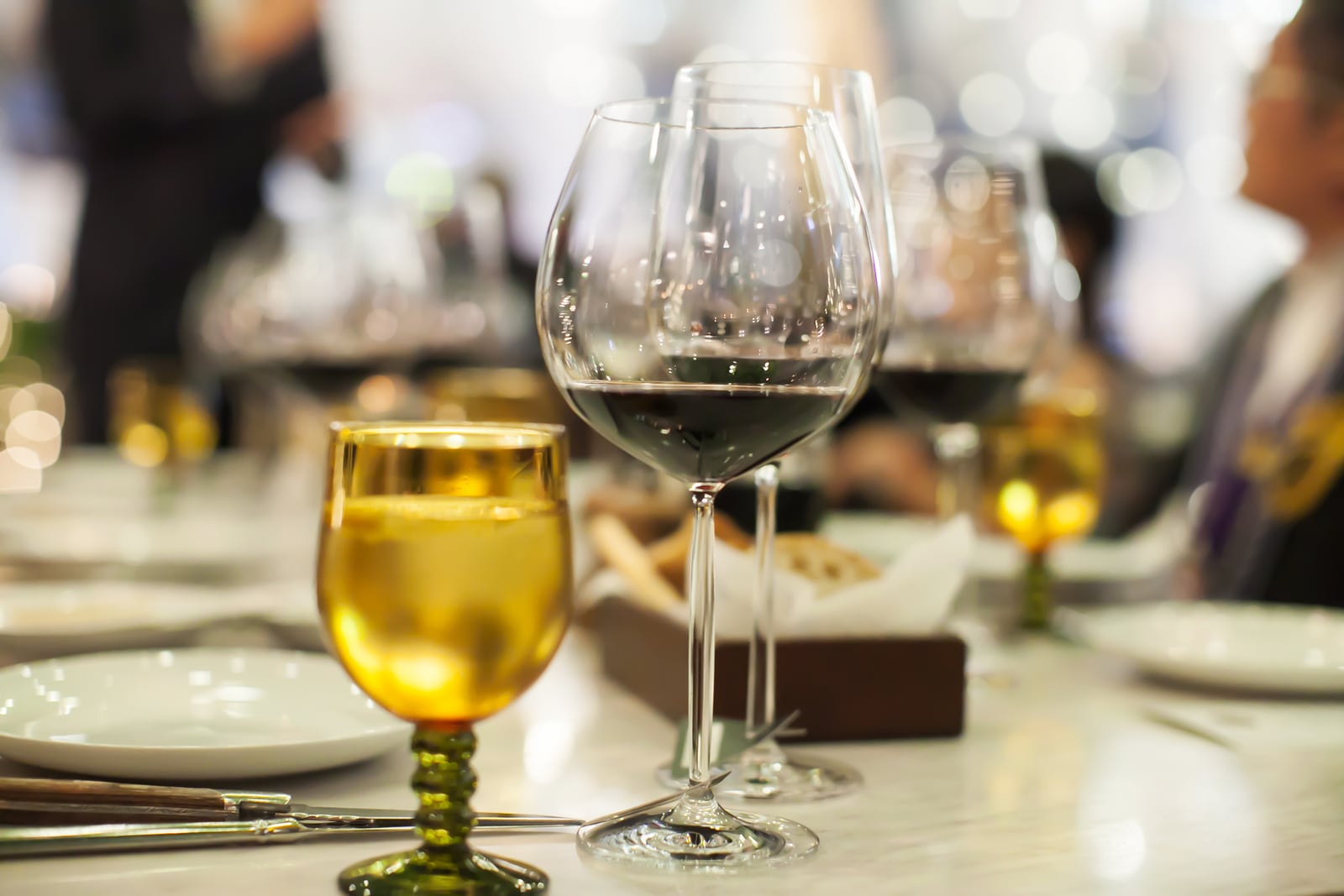 Wine glasses and place settings prepared for a formal dinner.